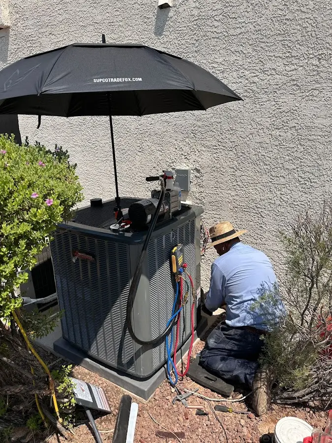 HVAC technician performing outdoor AC maintenance in Sun Village