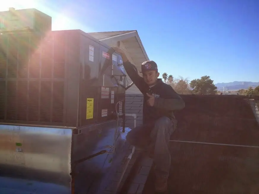 HVAC technician performing HVAC Inspection on a rooftop unit in Sun Village